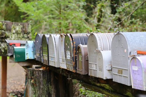 Grey mailboxes during daytime, showing the potential of mass letters and direct mail automation.